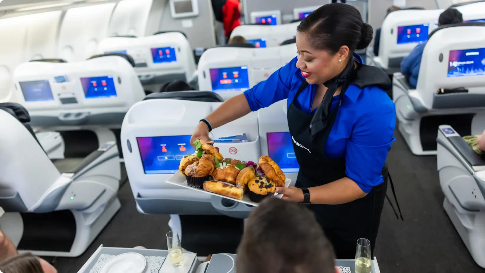 A flight attendant serving food to passengers